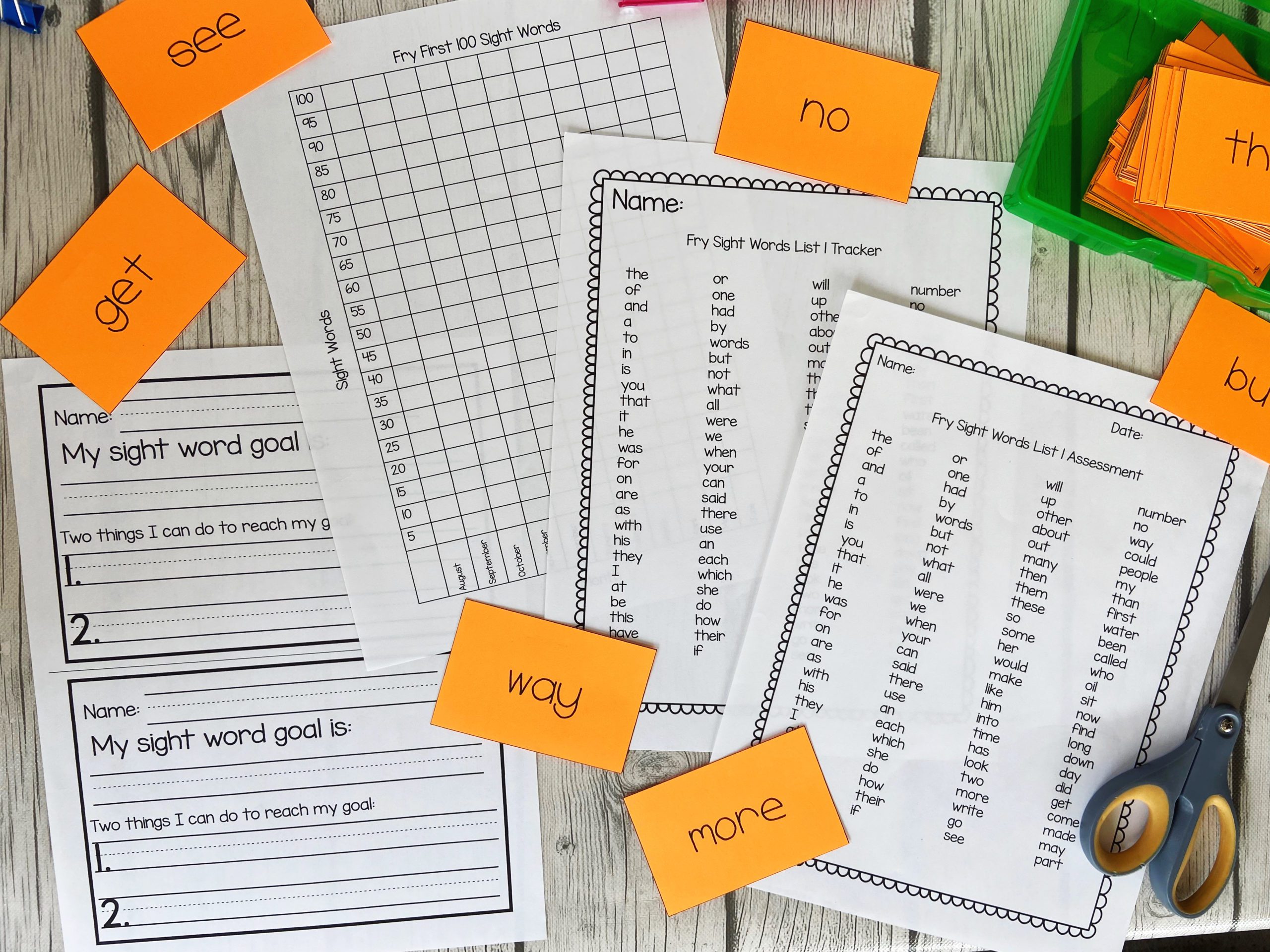 Orange word cards scattered around word lists and tracking pages for sight words. 